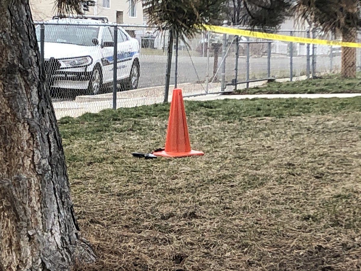 Police at home near shooting scene, crime scene tape up, gun on the ground